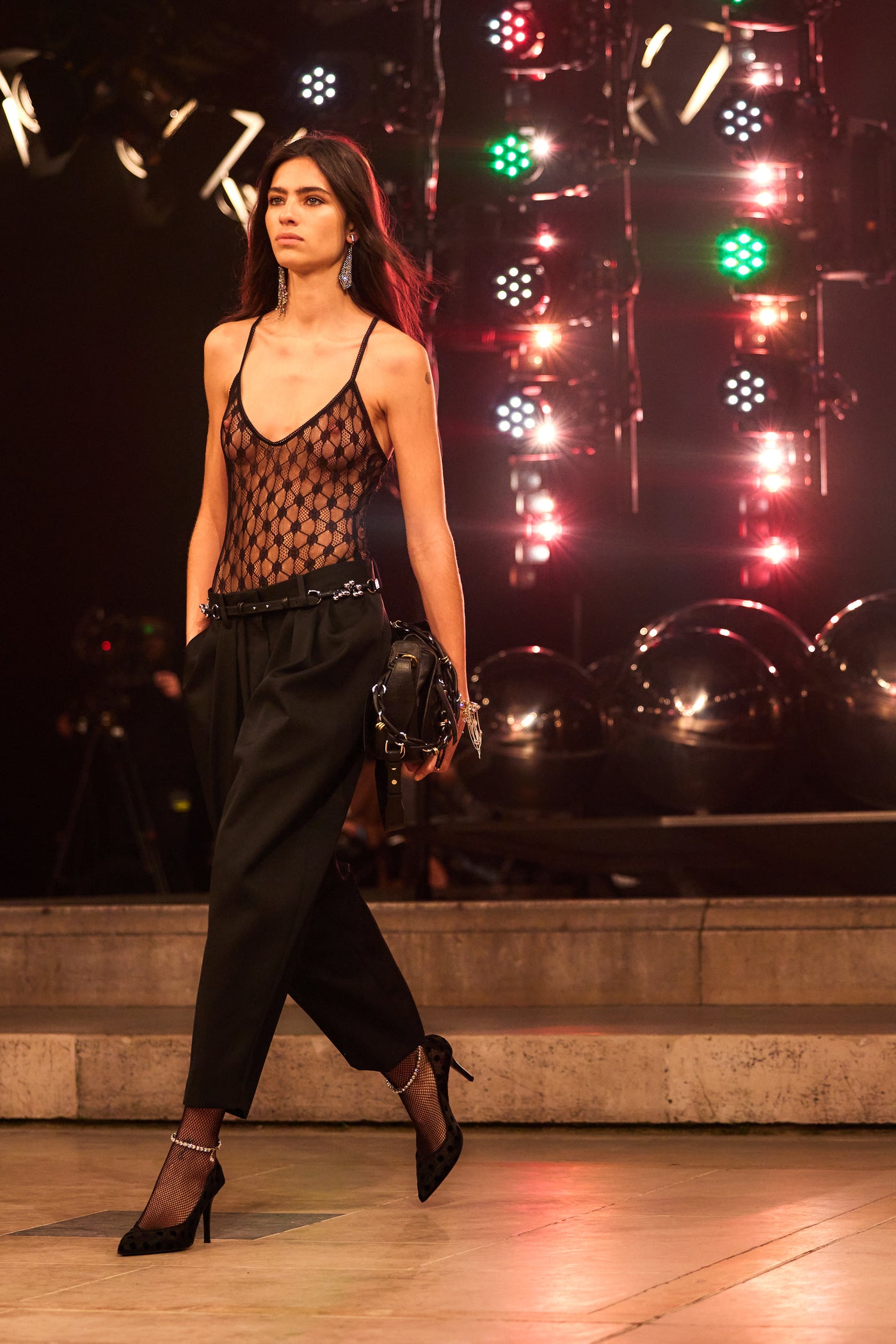 Model wears a High-leg tulle bodysuit with lace with black tights and black pumps with the Bolton bag.