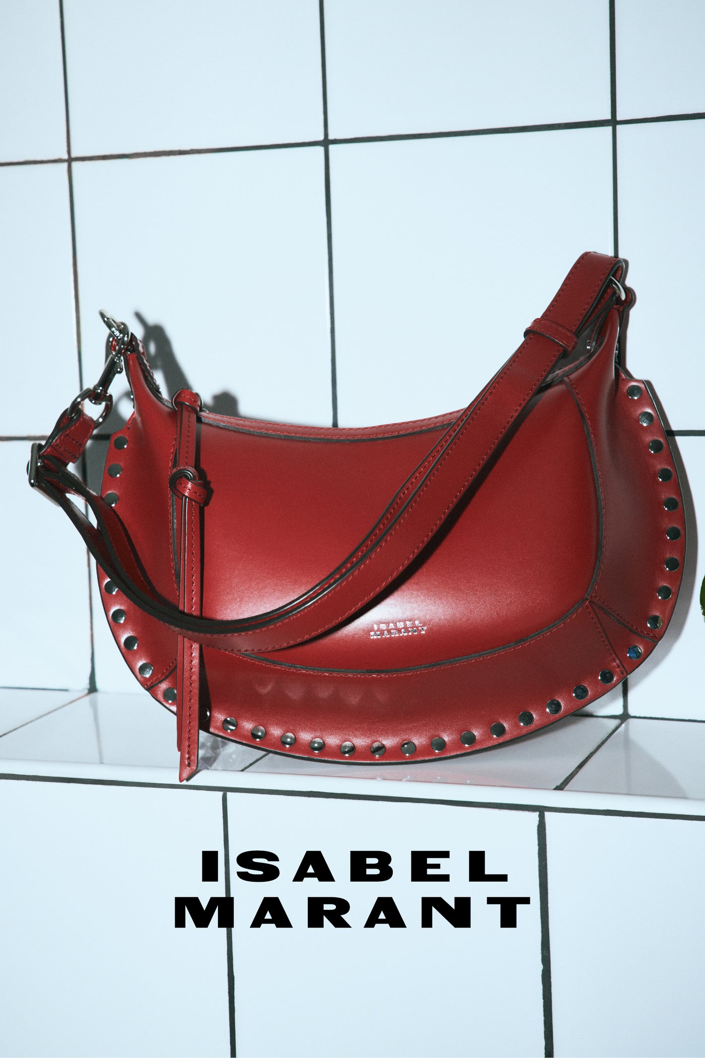 Red oskan moon bag on white wallRed oskan moon bag on white wall
