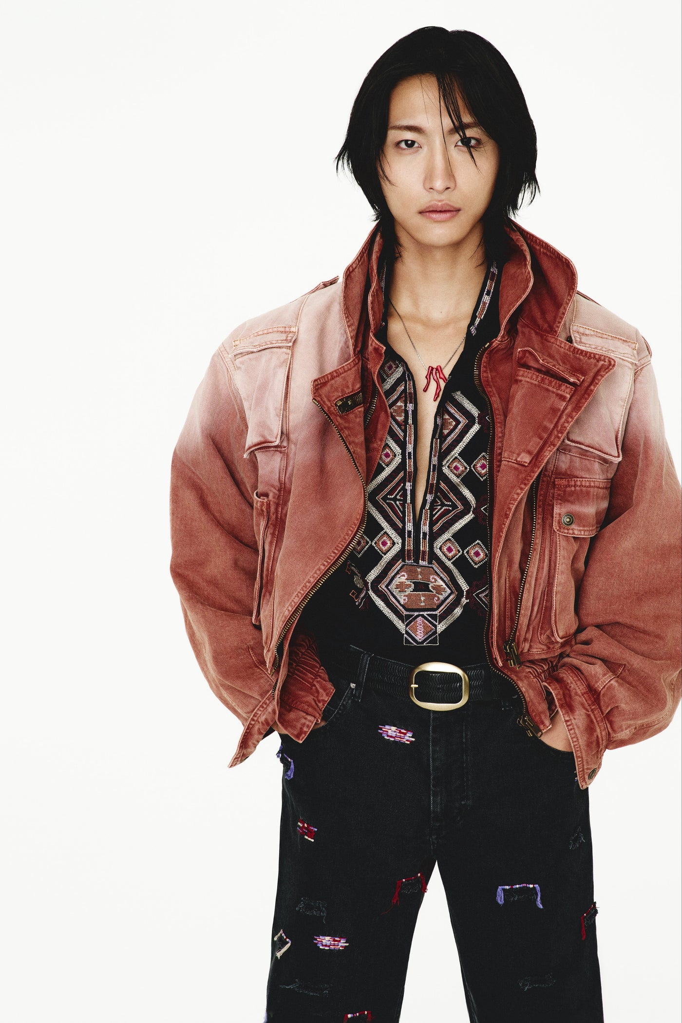 K-pop star Seonghwa is wearing SS25 menswear orange jacket with black pants and shirt
