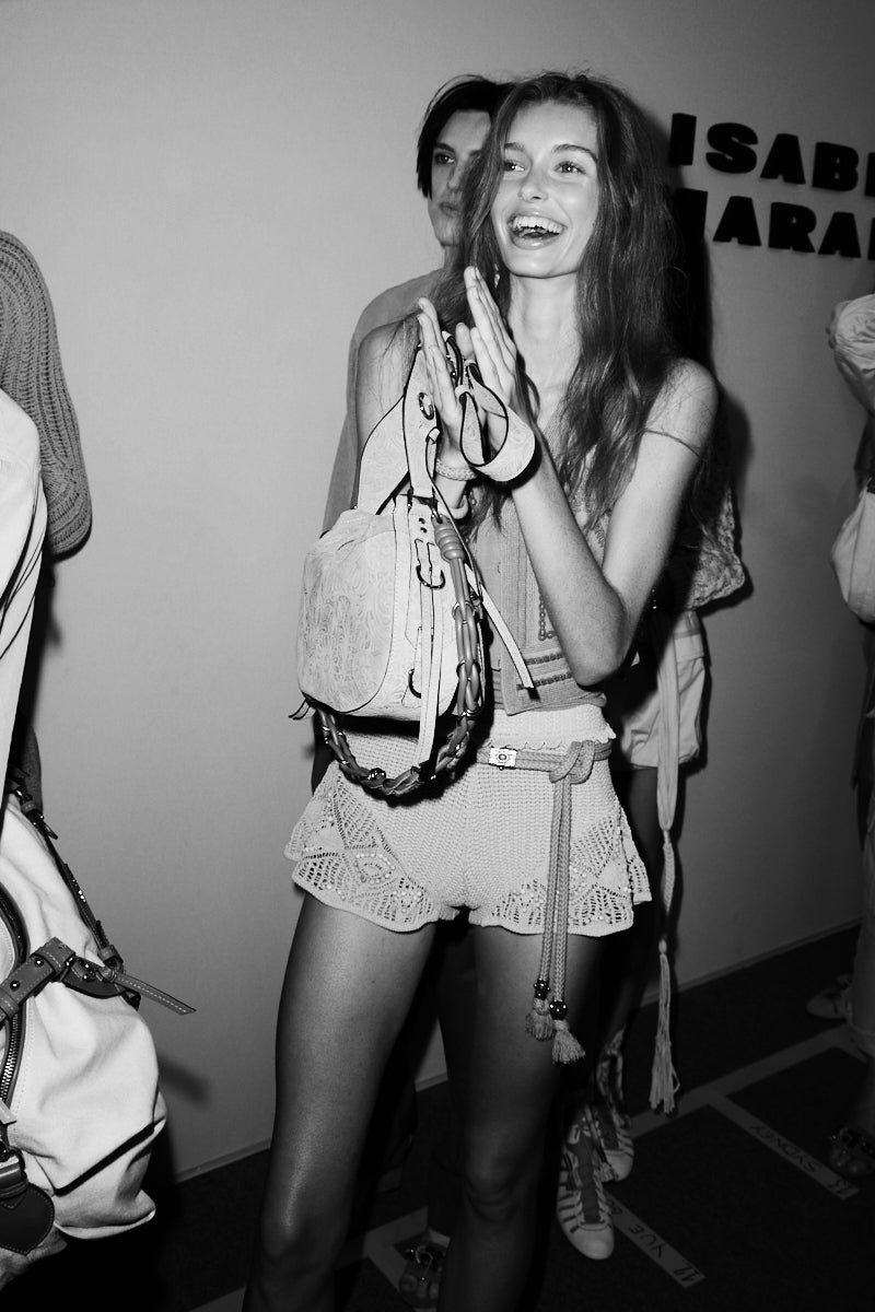 Models wearing a light khaki embroidered vest with knitwear short and a suede embossed bag bolton on a Black and White picture